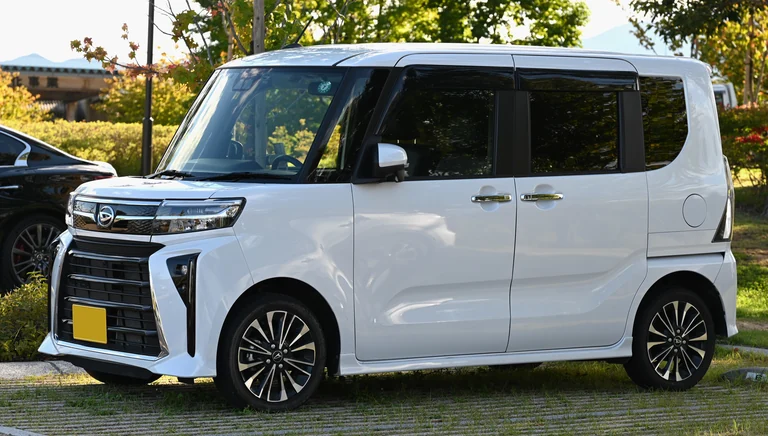 Daihatsu Tanto Custom RS после обновления 2022 года, белый кузов, крупная решётка с вертикальным рисунком и узкие фары, японский жёлтый номер