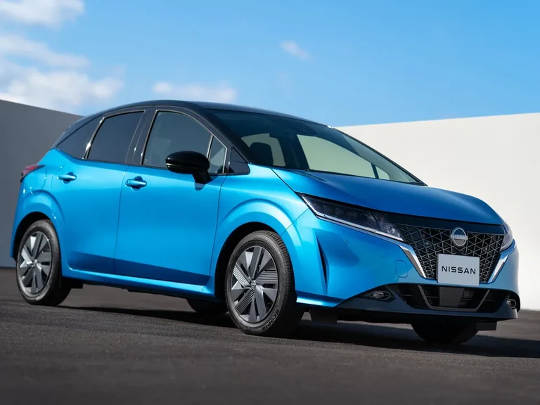 Nissan Note третьего поколения E13 2020–2023 годов, двухцветный синий хэтчбек с чёрной крышей, вид спереди-сбоку