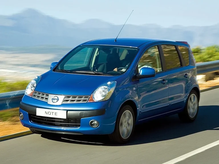 Nissan Note первого поколения E11 2005&ndash;2007 годов, синий хэтчбек в движении по горной дороге, вид спереди-сбоку