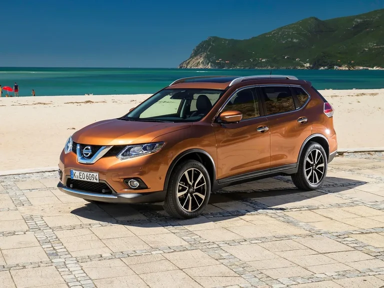 Nissan X-Trail третьего поколения до обновления 2017 года, оранжевый кроссовер с европейским номером, вид спереди-сбоку