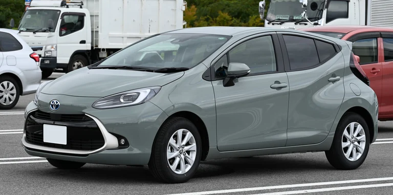 Toyota Aqua Z второго поколения, серо-зелёный хэтчбек на японской парковке, вид спереди-сбоку