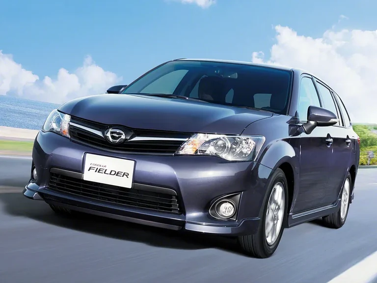 Toyota Corolla Fielder третьего поколения (E160), тёмно-серый универсал в движении по прибрежной дороге