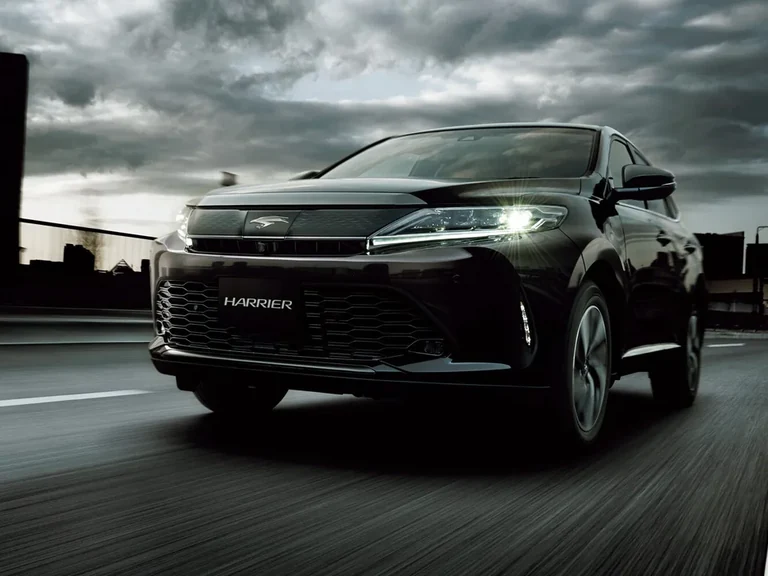 Toyota Harrier третьего поколения после обновления 2017 года, тёмный кузов, вид спереди в движении, табличка HARRIER на бампере
