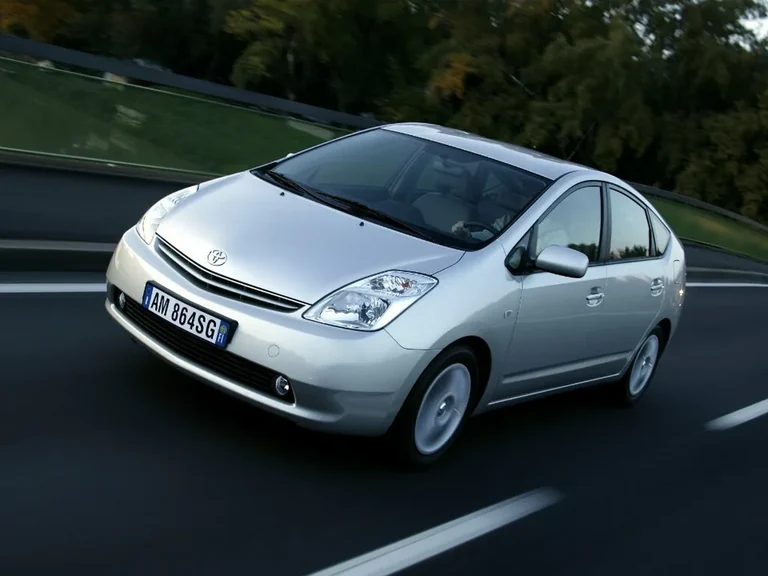 Toyota Prius NHW20 второго поколения, серебристый лифтбек в движении, вид спереди-сбоку