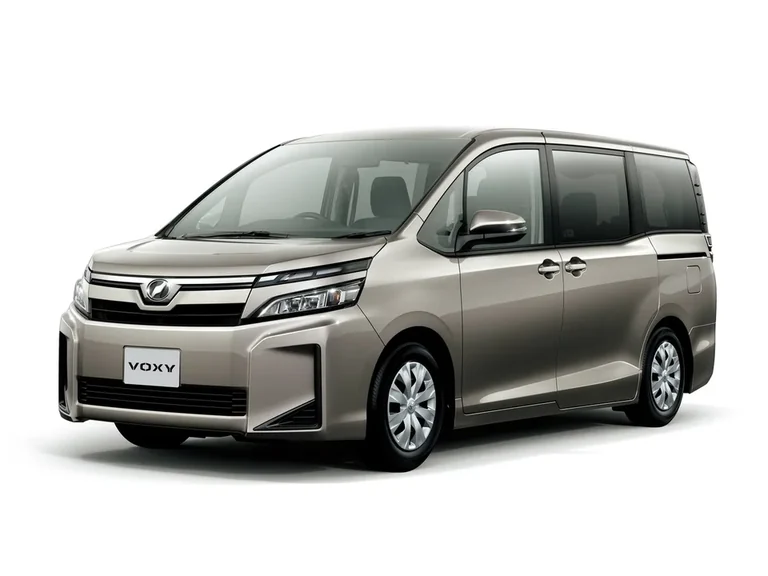Toyota Voxy третьего поколения после обновления 2017 года, серебристо-бежевый кузов, студийный кадр, табличка VOXY на бампере
