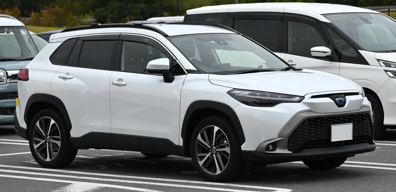 Toyota Corolla Cross Hybrid Z первого поколения для японского рынка, белый кроссовер, вид спереди-сбоку